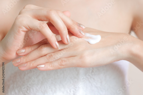 Woman applying moisturizing cream lotion on hands  beauty concept.