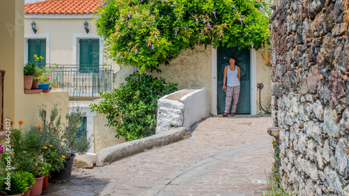 Fototapeta Naklejka Na Ścianę i Meble -  Woman walking through streets of Greek Village