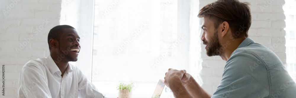 Fototapeta premium Horizontal photo diverse workers having fun at workplace discuss interesting project, share ideas, multiracial workmates friendship concept, banner for website header design with copy space for text