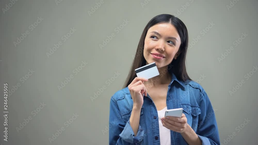 Attractive woman entering credit card number on smartphone, shopping online Attractive woman entering credit card number on smartphone, shopping online