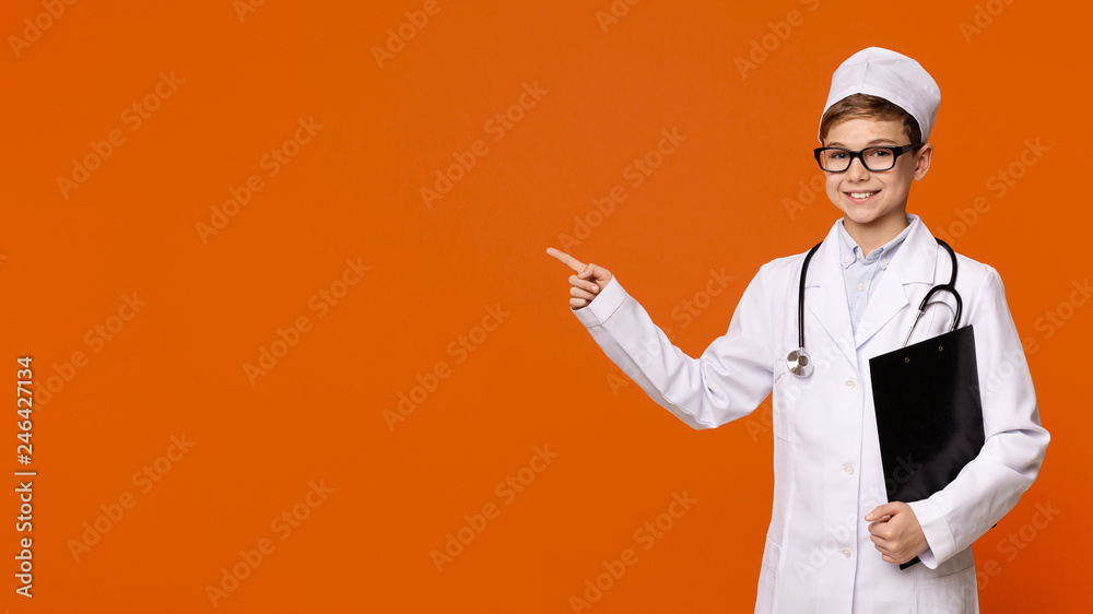Cute smiling boy playing doctor on orange background