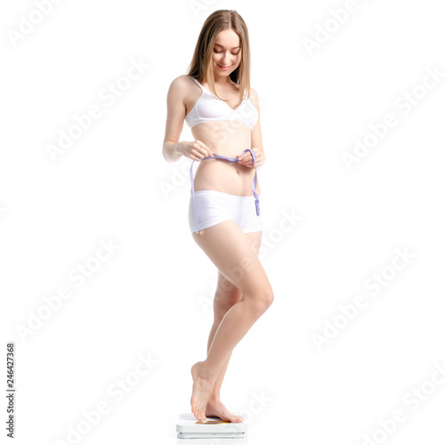Beautiful woman standing on weighing scale centimeter weight loss on white background isolation