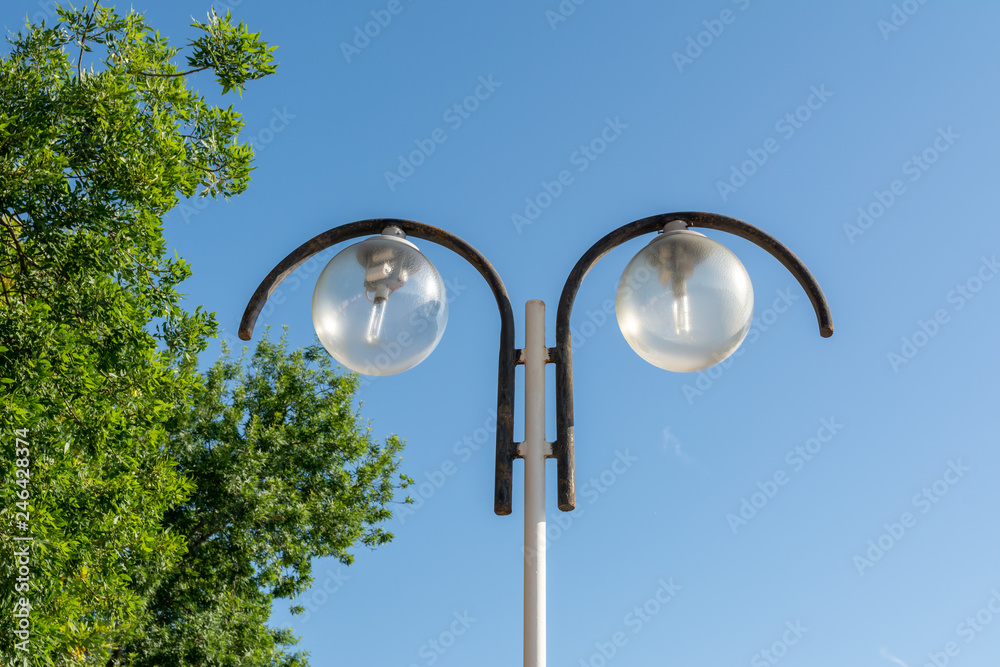 Street lamp with circular shades on the background of blue sky Street lamp with circular shades on the background of blue sky