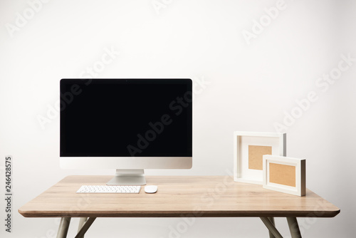 workplace with photo frames and desktop computer with copy space isolated on white