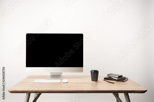 workplace with coffee to go, notebooks and desktop computer with copy space isolated on white