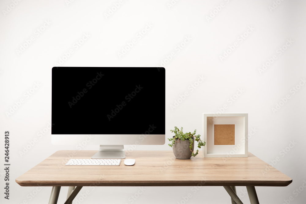 workplace with green plant, photo frame and desktop computer with copy space isolated on white workplace with green plant, photo frame and desktop computer with copy space isolated on white