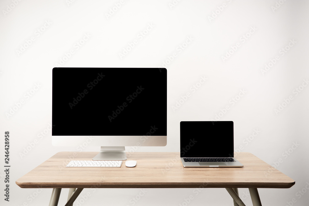 workplace with desktop computer and laptop with copy space on wooden table isolated on white workplace with desktop computer and laptop with copy space on wooden table isolated on white