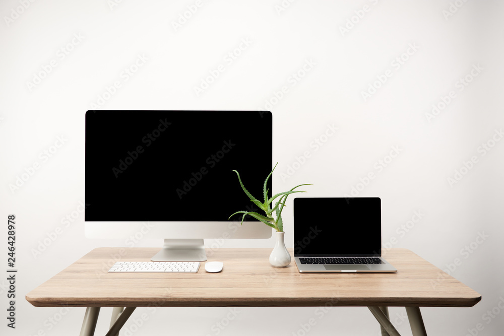 workplace with desktop computer and laptop with copy space on wooden table isolated on white workplace with desktop computer and laptop with copy space on wooden table isolated on white