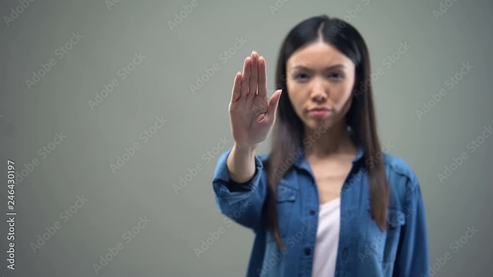 Lady pulling hand forward, showing stop sign, racial and gender discrimination Lady pulling hand forward, showing stop sign, racial and gender discrimination