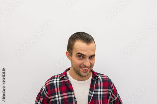 Portrait, young guy in casual clothes with positive smile, looking at camera, white, background, copy space, advertising, slogan, front view
