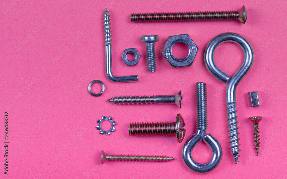 Abstract pink plastic background with screws nuts and washers Abstract pink plastic background with screws nuts and washers