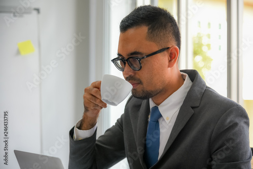 Asian businessmen Drinking coffee During work at workplace to business concept. photo