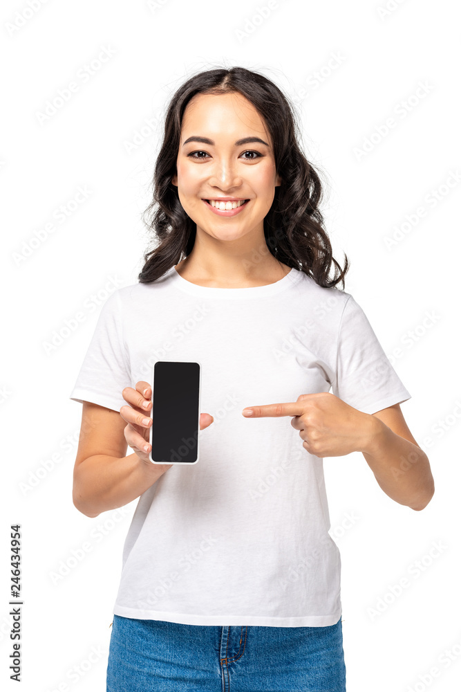 Young asian girl pointing at smartphone with blank screen isolated on white Young asian girl pointing at smartphone with blank screen isolated on white