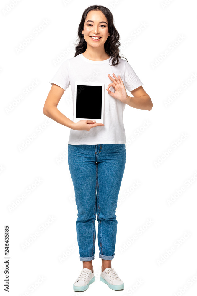 Smiling asian woman holding digital tablet with blank screen and showing ok gesture isolated on white Smiling asian woman holding digital tablet with blank screen and showing ok gesture isolated on white