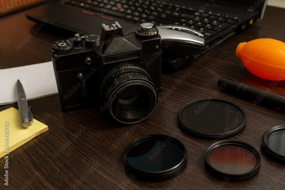 Workspace of professional photographer. Photography and office equipment on the dark desktop.