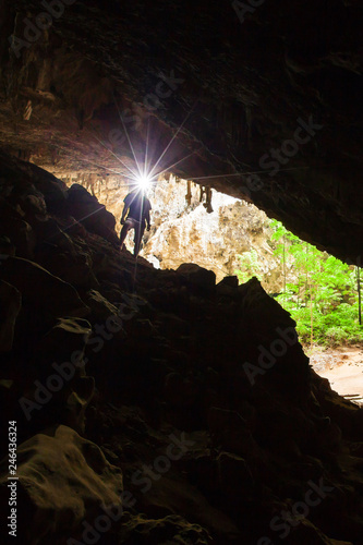 Young man exploring mystic cave with a torch. photo