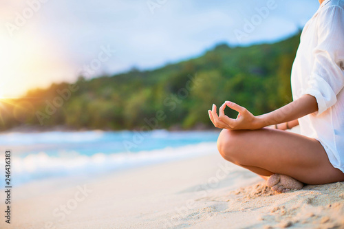 Fototapeta Naklejka Na Ścianę i Meble -  Closeup of Woman's Practicing Lotus Pose on the Beach at Sunset