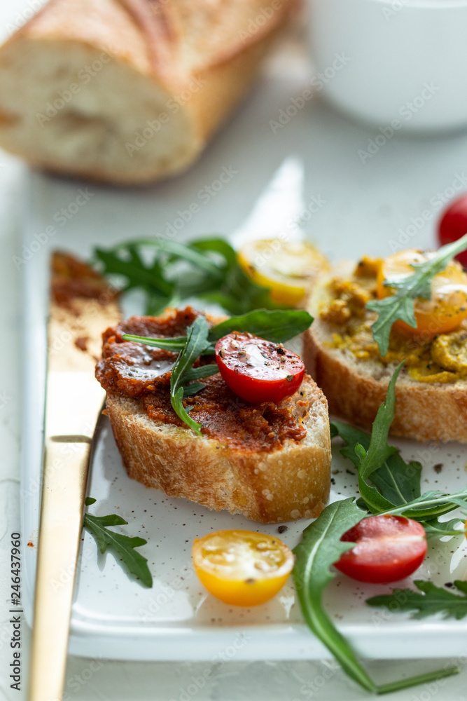 bruschettas with chopped tomato and basil on white ceramic plate. bruschettas with chopped tomato and basil on white ceramic plate.