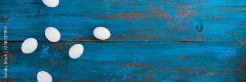 Frame of Easter eggs with a place for the inscription on a blue wooden background. Copy space .