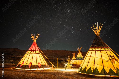 Valokuva Illuminated Native American Teepees under glowing night sky