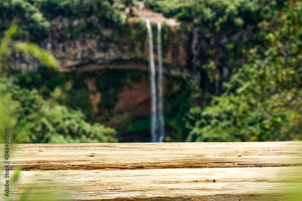 Wooden table on the background of a waterfall on a summer day Wooden table on the background of a waterfall on a summer day