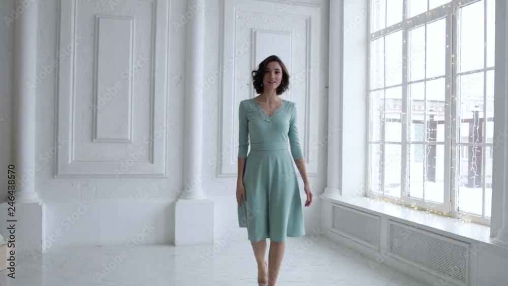 A young girl is spinning in a gray dress in a white room. The brunette is spinning and goes ahead in a dress and laughs, slow motion 1920x1080 A young girl is spinning in a gray dress in a white room. The brunette is spinning and goes ahead in a dress and laughs, slow motion 1920x1080