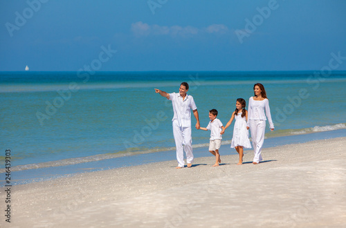 Mother, Father and Children Family Walking on Beach © Darren Baker