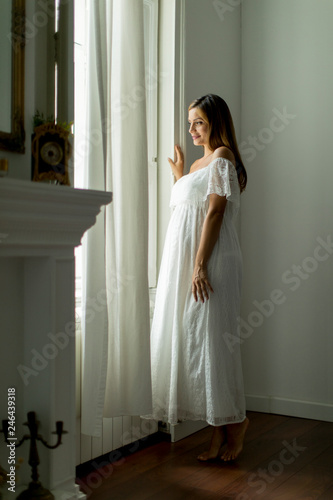 Young pregnant woman standi...