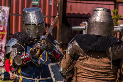 Medieval knights fighting with armor, swords and shields in festival