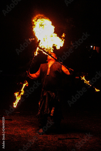 fire-eater in night show at medieval festival with black background