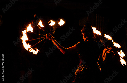 fire-eater, fire dancer with flaming hoop in night show at medieval festival with black background, fire dancer with flaming hoop in night show at medieval festival with black background