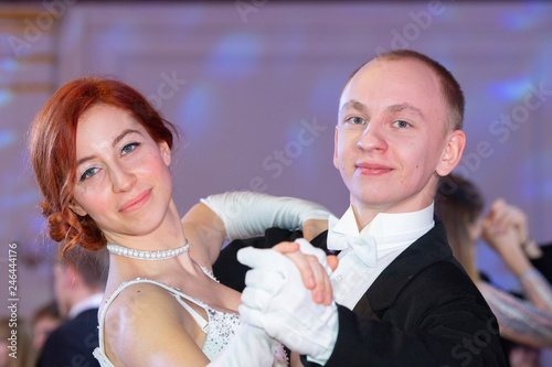 Young good looking couple in evening dress and dress coat posing in elegant way in a classical style