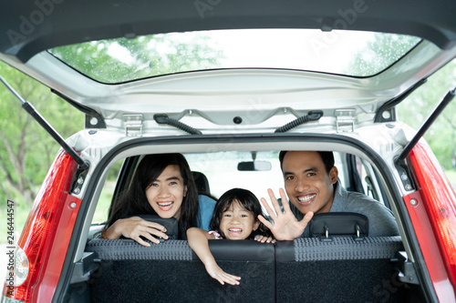 mother, father, and his daughter inside a car look out from back windows © Odua Images