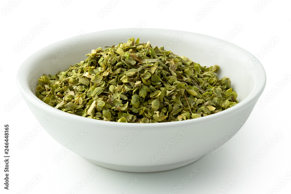 Dried chopped oregano in white ceramic bowl isolated on white. Dried chopped oregano in white ceramic bowl isolated on white.