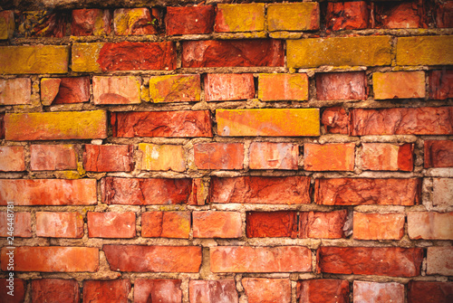 red brick wall with moss texture grunge background with vignetted corners