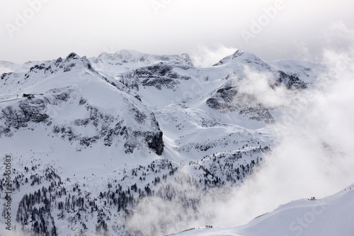 A picture from the Alps in Austria. A view on peaks and valleys covered by snow and mist.
