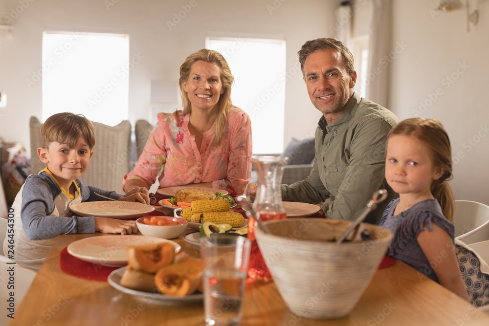 Happy family sitting on dining table at home Happy family sitting on dining table at home