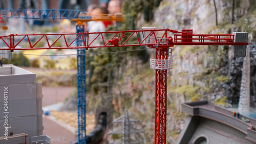 Construction site of new house with apartments with working lifting crane, new many-storied building in miniature