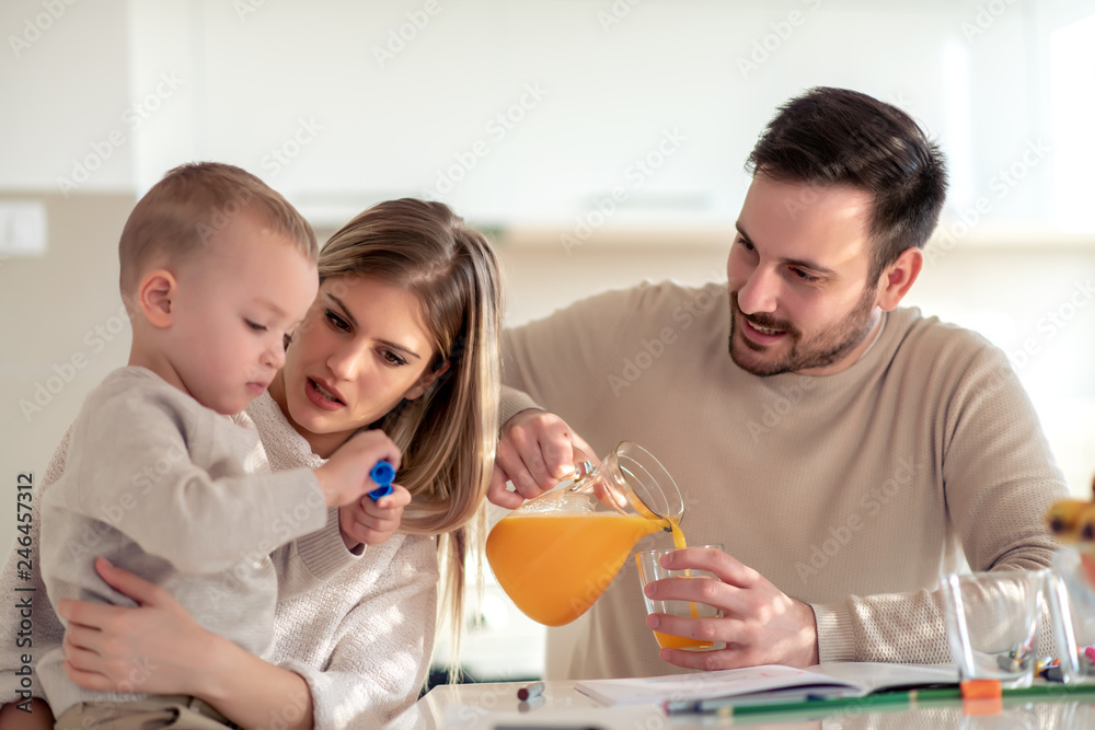 Family with child having fresh fruit juice at home Family with child having fresh fruit juice at home