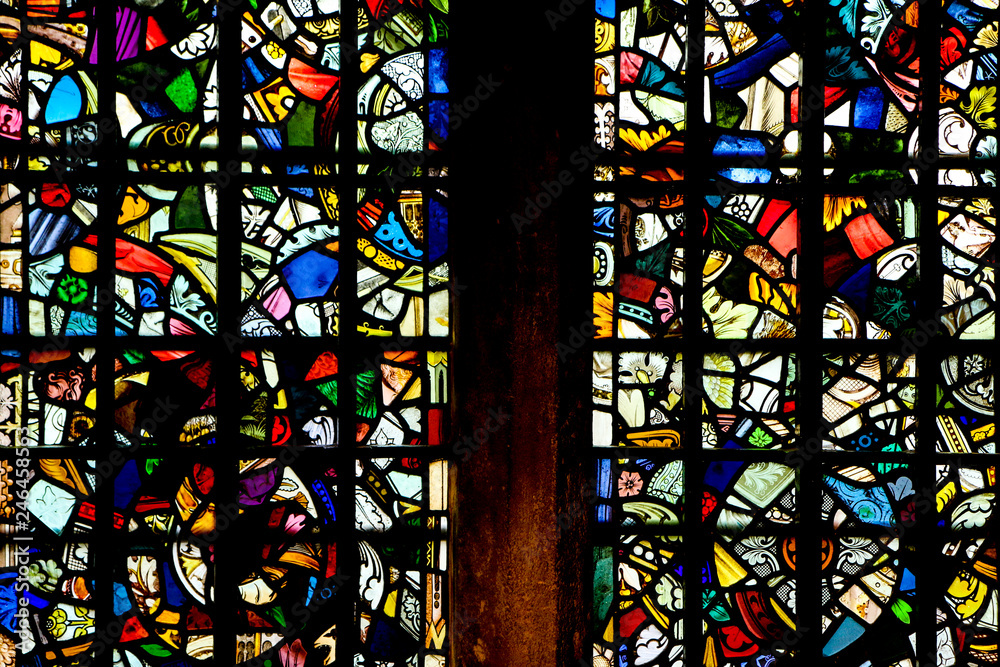 A picture of an old colorful stained glass made of pieces of different colorful glass.