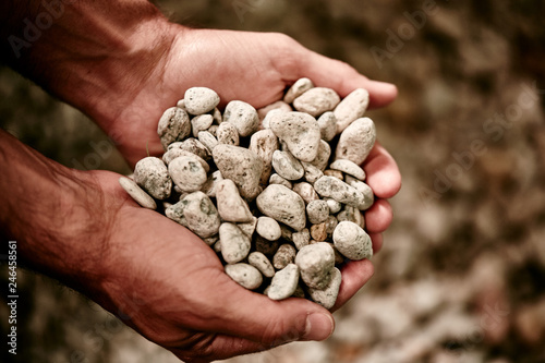 male hands holding stones for denim stone washing photo