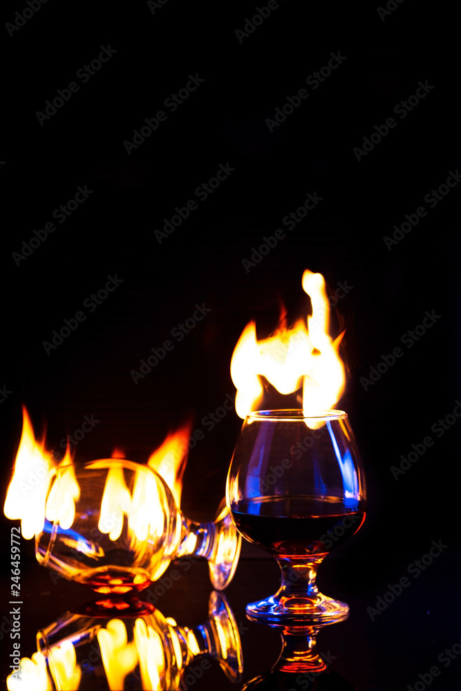 Two Glasses with burning alcohol dark background