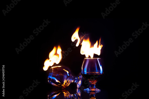 Two Glasses with burning alcohol dark background