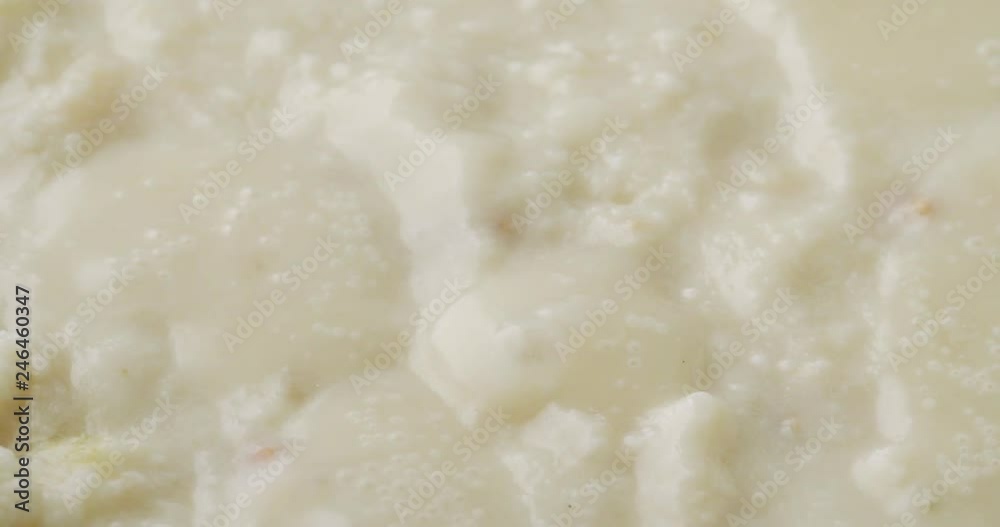 Close video of heating canned clam chowder to a boil in a pan. Close video of heating canned clam chowder to a boil in a pan.