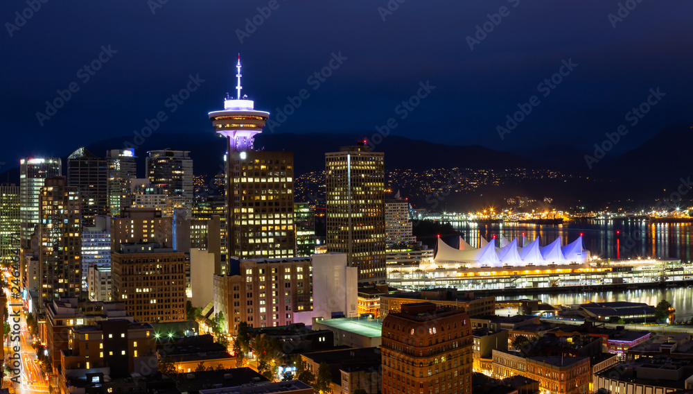Fototapeta premium Beautiful view of the modern cityscape from an aerial perspective at night. Taken in Downtown Vancouver, BC, Canada.