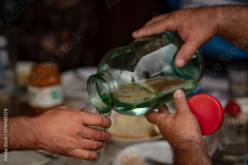 Valokuva Bottling of moonshine from a large jar