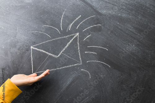 hand with mail envelope drawn on the blackboard