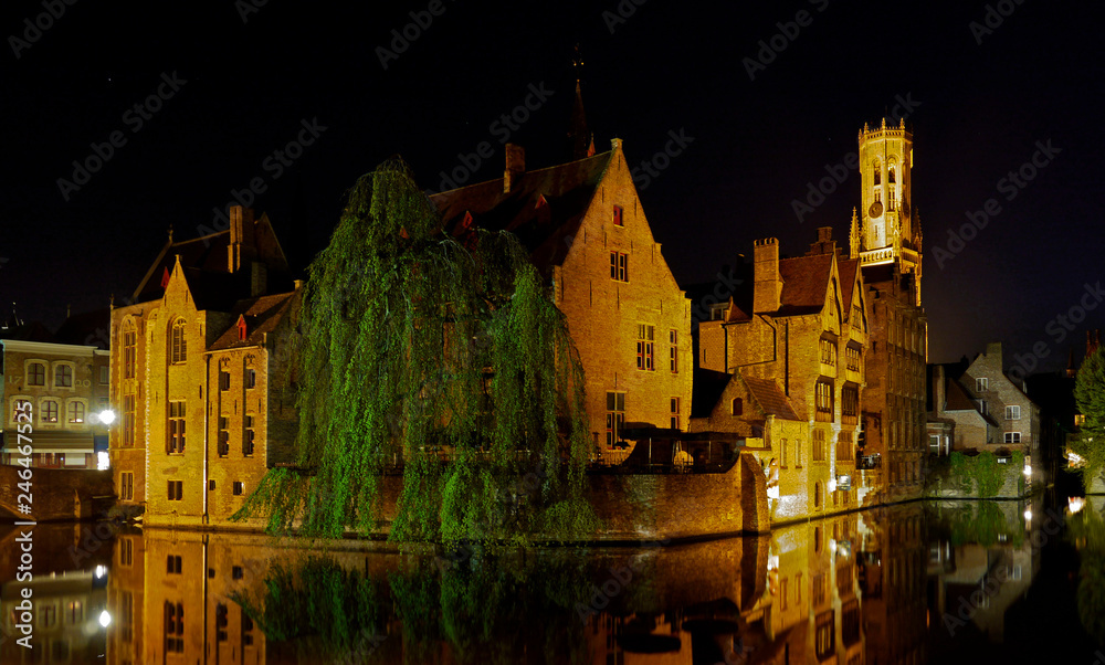 Bruges, West Flanders / Belgium - May 2013: The Rosary Quay illuminated at night with the Belfry in the distance