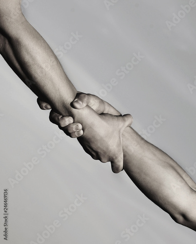 Two hands, helping hand of a friend. Rescue, helping gesture or hands. Strong hold. Handshake, arms, friendship. Friendly handshake, friends greeting, teamwork, friendship. Close-up. Black and white photo