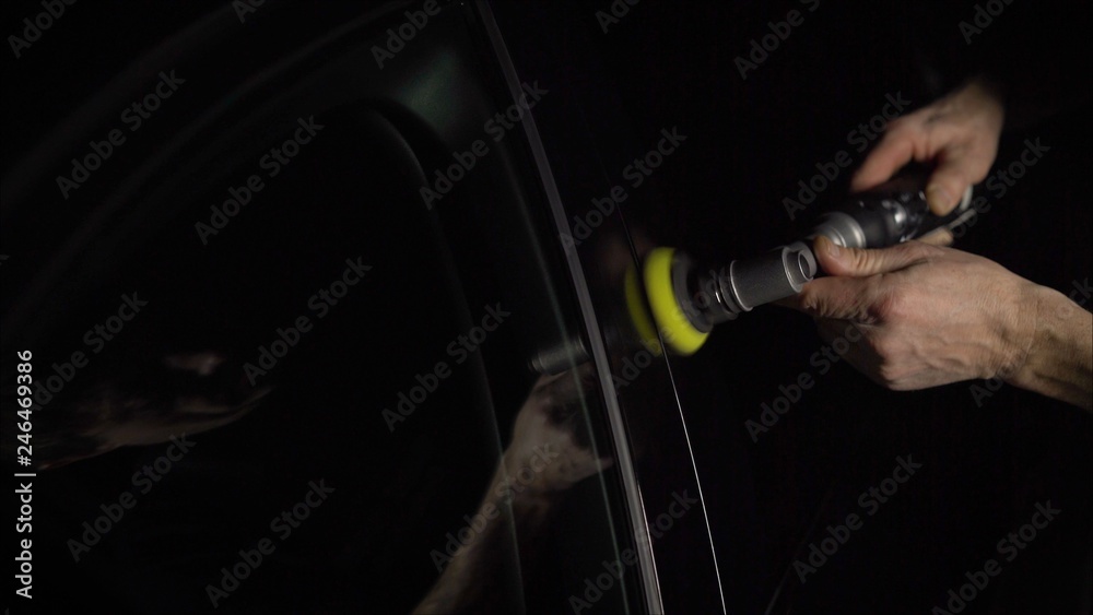 Car detailing - Hands with orbital polisher in auto repair shop. Selective focus. Car detailing - Hands with orbital polisher in auto repair shop. Selective focus.